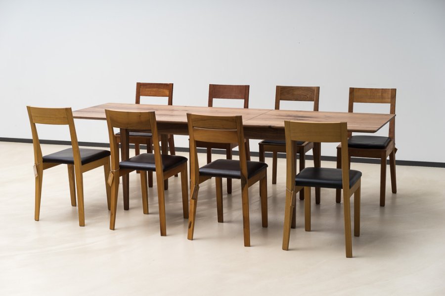 8 Elan Stühle aus verschiedenen Hölzern am Tisch Classic